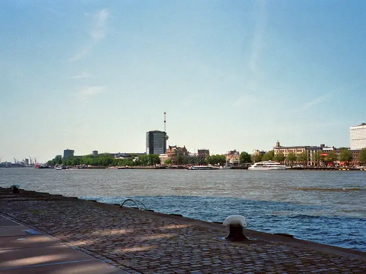 The Rotterdam waterfront seen across the Maas from a cobbled quayside